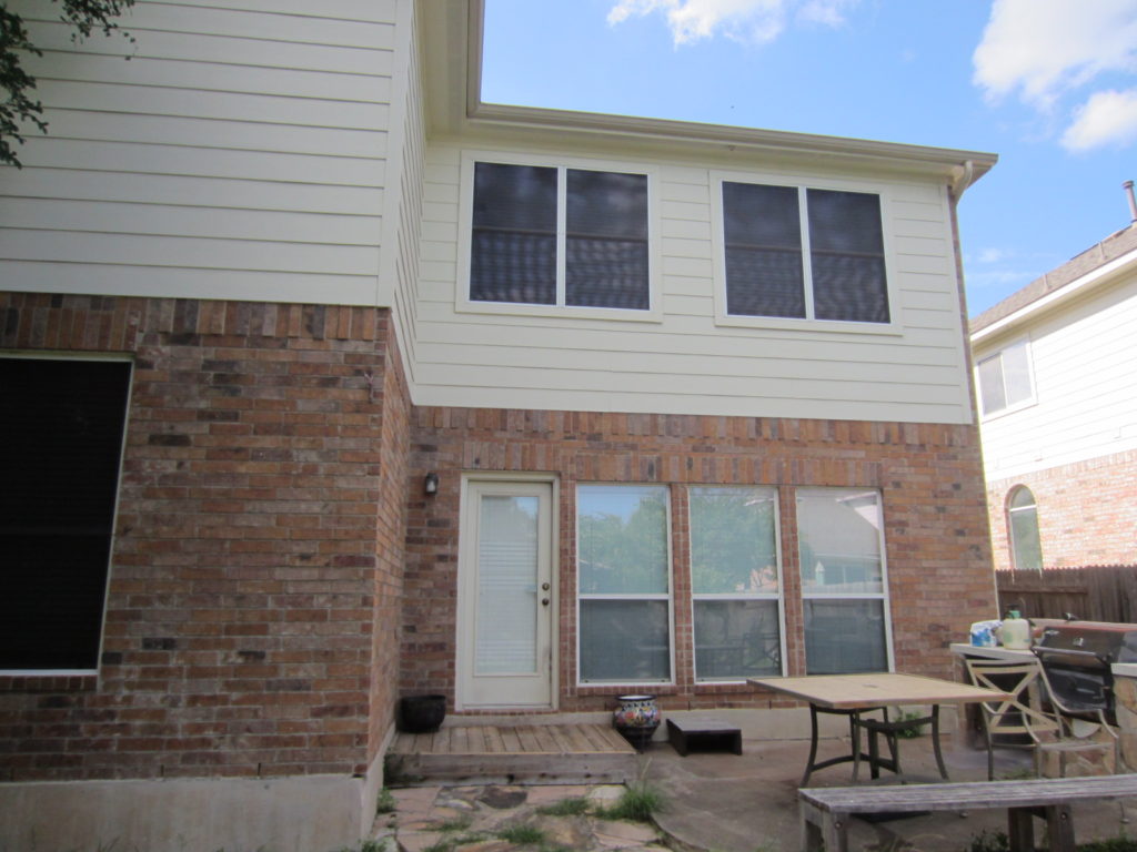 This is a great picture showing windows uncovered next to windows covered with solar screens. It is not illustrating a covered patio, nevertheless, it does clearly show what it looks like to have some windows covered with solar screens and some not.