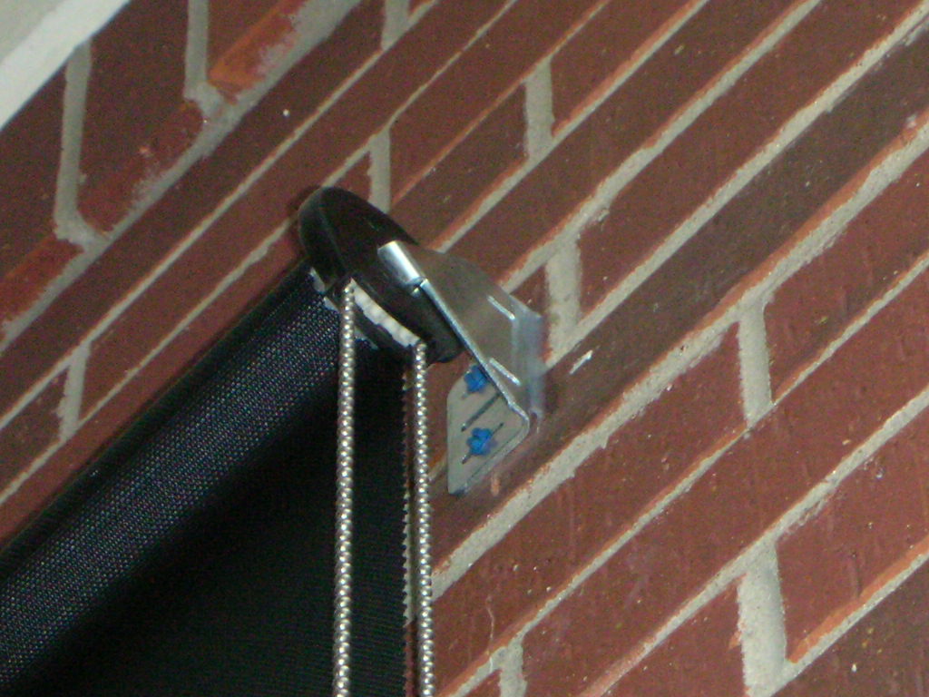 Clutch, bracket and tapcon screws for exterior patio roller shades mounted to shade a front door. 