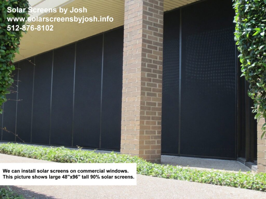 Large exterior solar screens installed on commercial brick building windows in Austin Texas